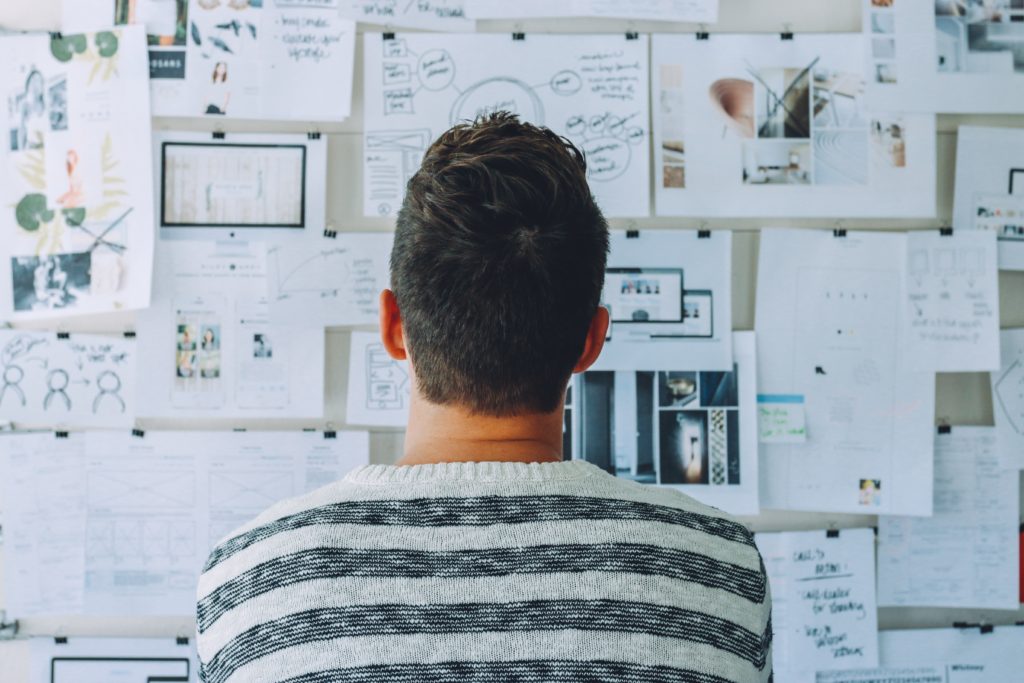 Man looking at an organisation board to plan his budget and travel.